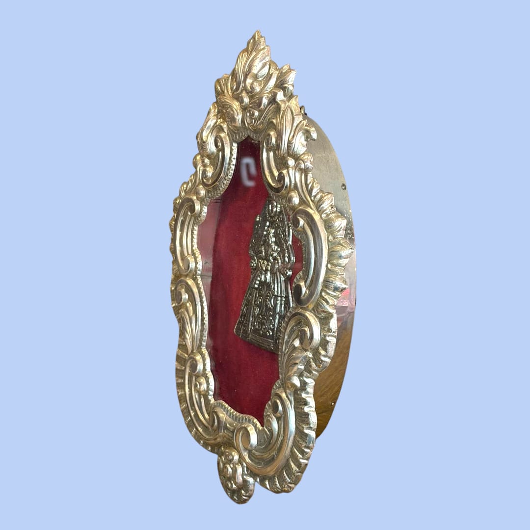 Relicario Virgen con Niño en marco plateado con fondo burdeos, arte sacro único ideal para altar religioso o colección devocional.