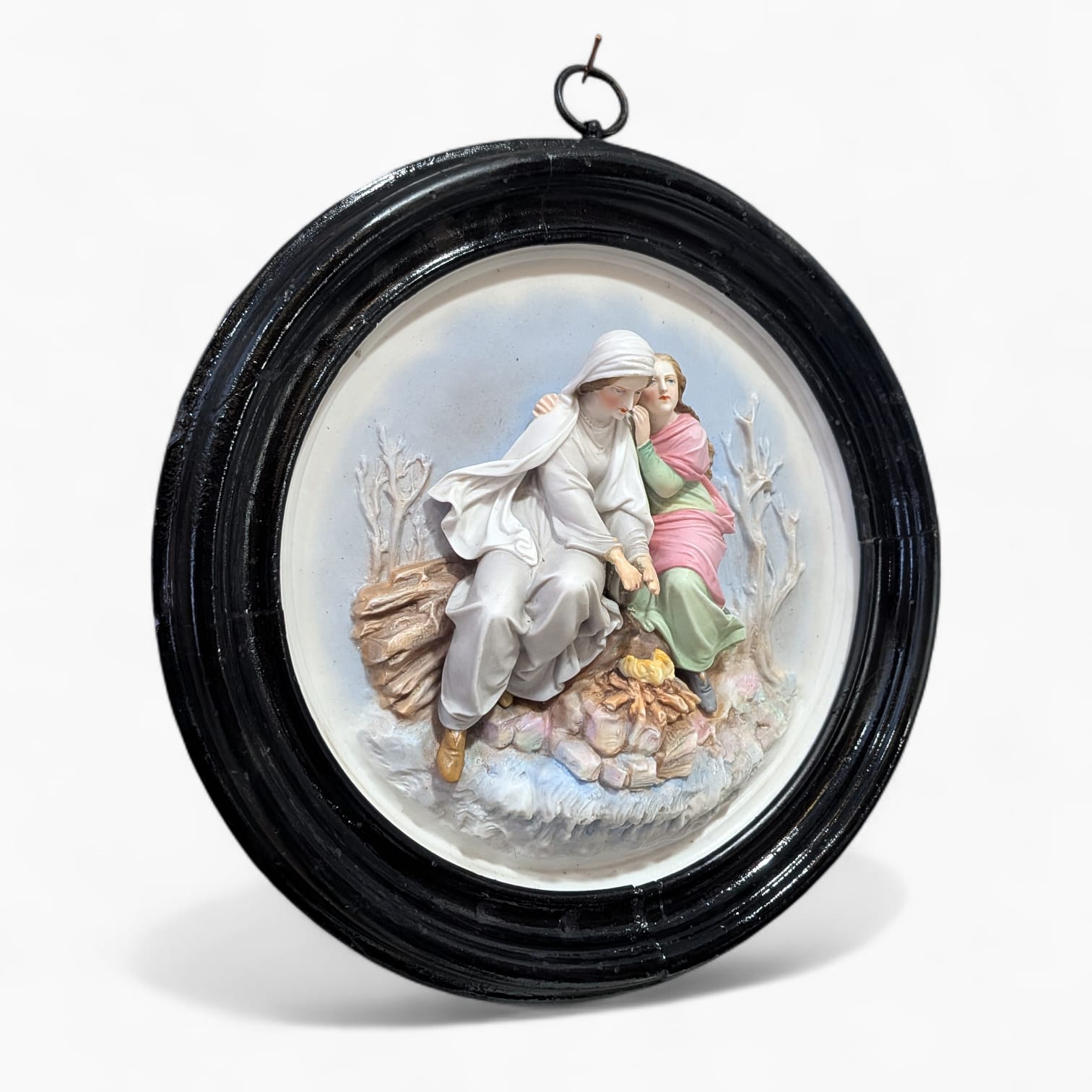 Decoración mural clásica en porcelana con escena figurativa restaurada, marco oval negro y detalles en relieve para colgar en pared.