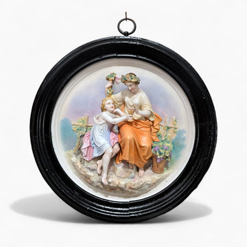 Relieve de porcelana antiguo restaurado escena figurativa con marco negro circular. Decoración clásica para pared en estilo romántico.