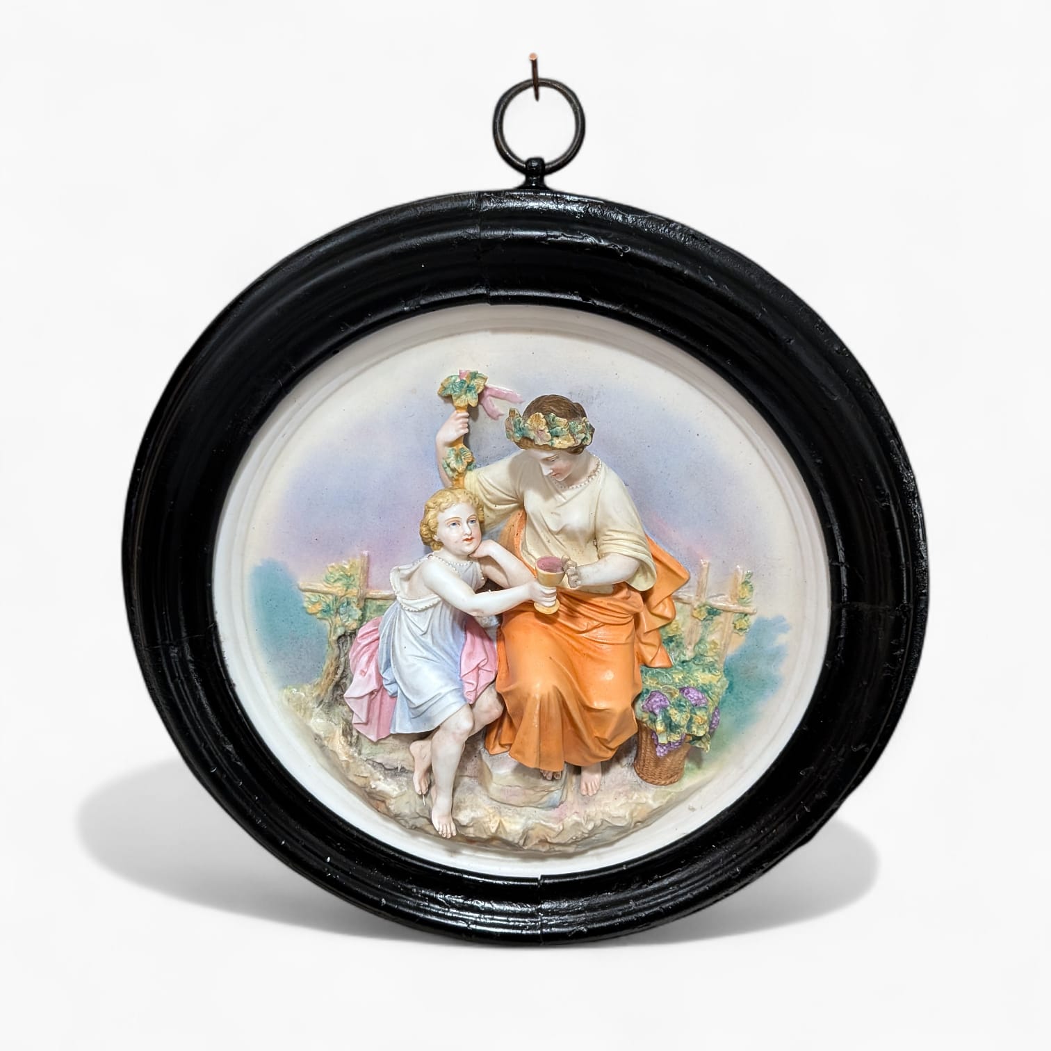 Relieve de porcelana antiguo restaurado con marco negro y escena figurativa de inspiración clásica. Pieza única para decoración de pared.