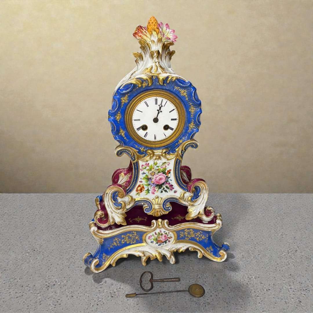 El Reloj de porcelana Jacob Petit es una pieza excepcional del siglo XIX, elaborado en lujosa porcelana policromada y ricamente decorado con motivos florales, detalles dorados y elementos rococó característicos del estilo Luis XV. 
