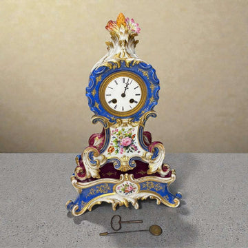 El Reloj de porcelana Jacob Petit es una pieza excepcional del siglo XIX, elaborado en lujosa porcelana policromada y ricamente decorado con motivos florales, detalles dorados y elementos rococó característicos del estilo Luis XV. 