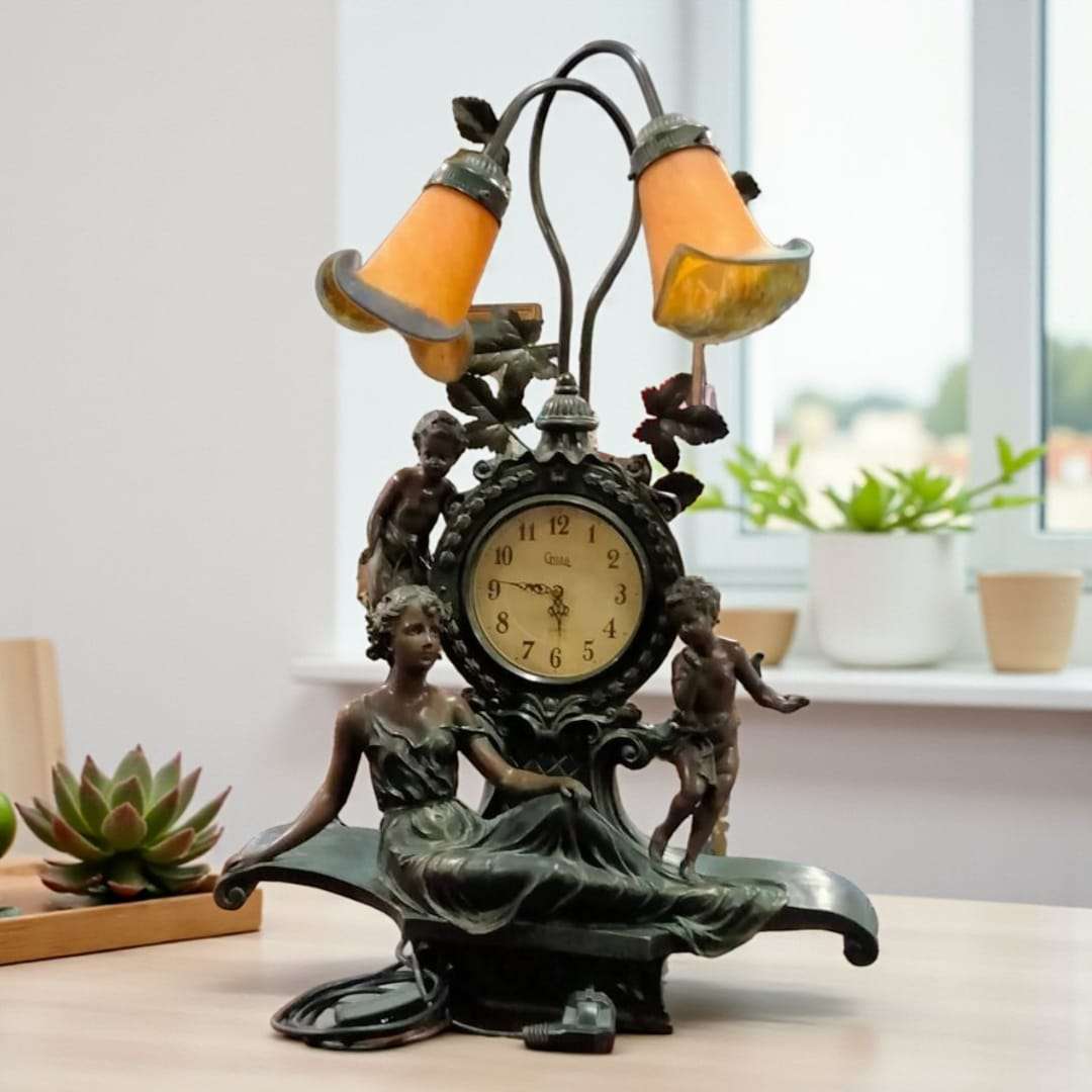 Lámpara/reloj de sobremesa en resina con acabado en bronce.