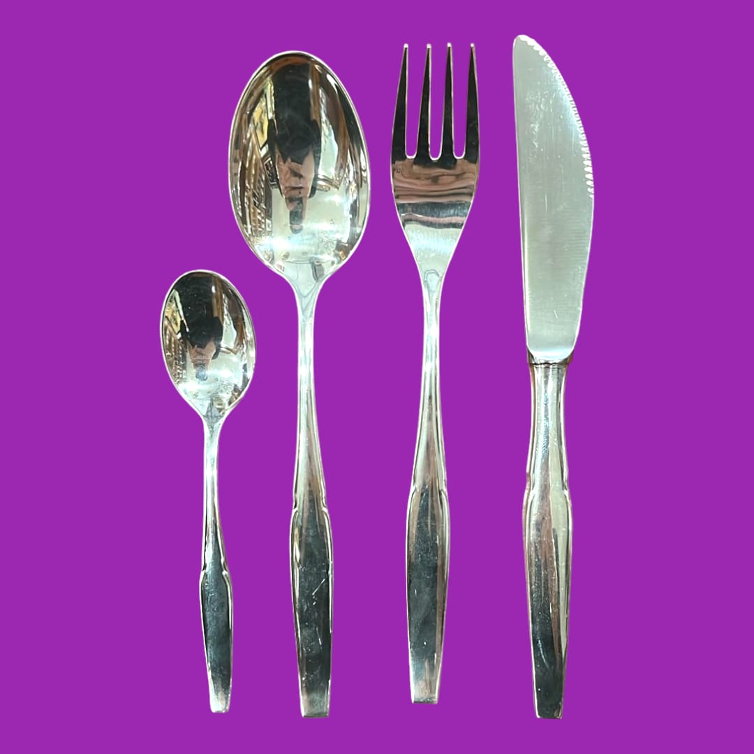 Juego completo de restos de cubertería de metal plateado con diseño clásico, ideal para decoración de mesa elegante en el hogar.