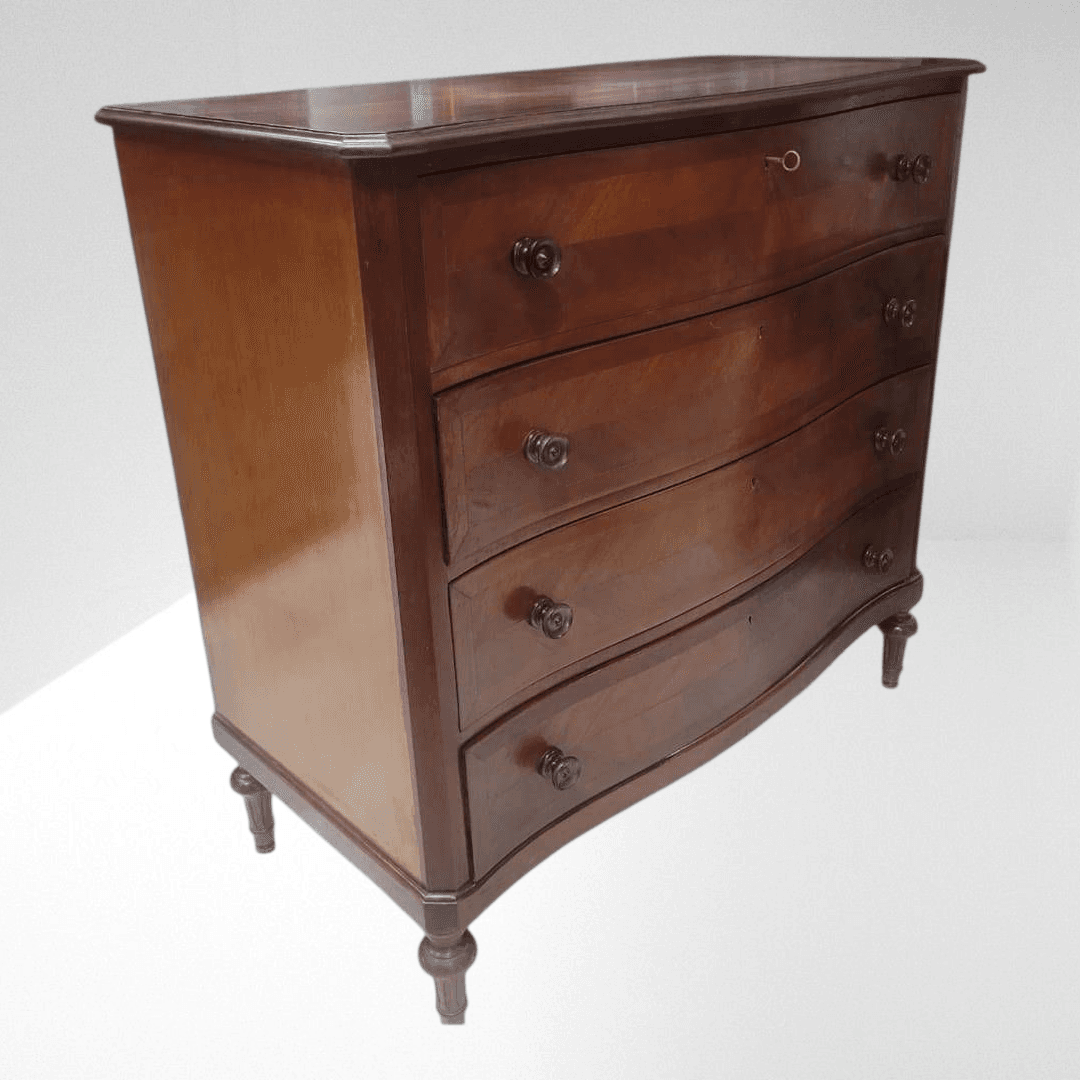 Cómoda de caoba antigua de 4 cajones elegante y funcional con diseño ondulado y tiradores tallados, ideal para decoración vintage en interiores clásicos.