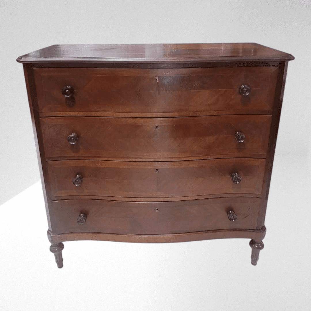 Cómoda de caoba antigua de 4 cajones elegante y funcional con diseño ondulado y tiradores tallados, ideal para decoración vintage en interiores clásicos.