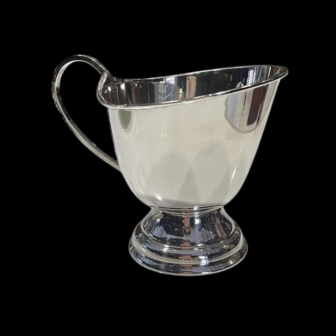 Vista frontal de la Salsera de metal plateado sobre su platillo.