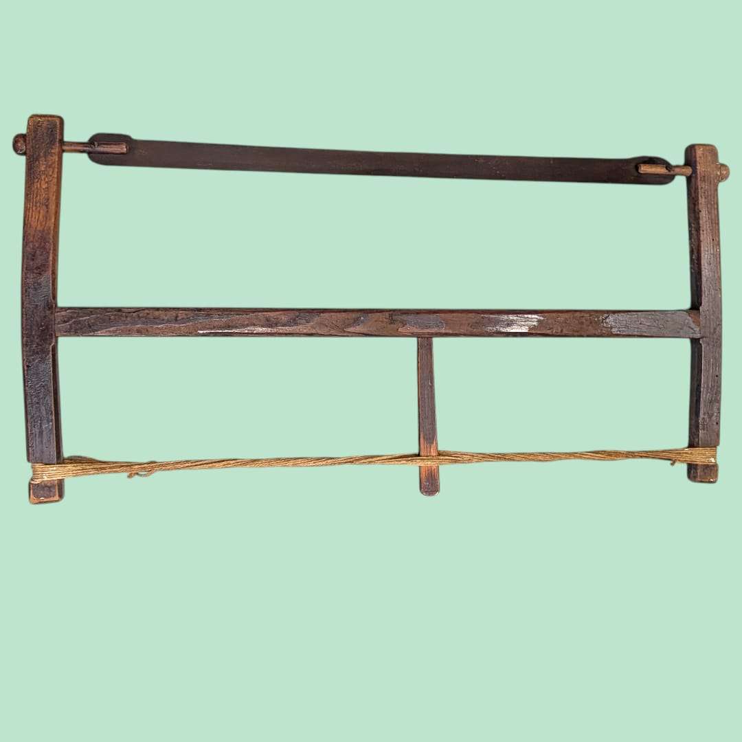 Sierra de arco manual antigua de madera con cuerda de tensión, herramienta original de carpintería ideal para decoración rústica en hogar y jardín.