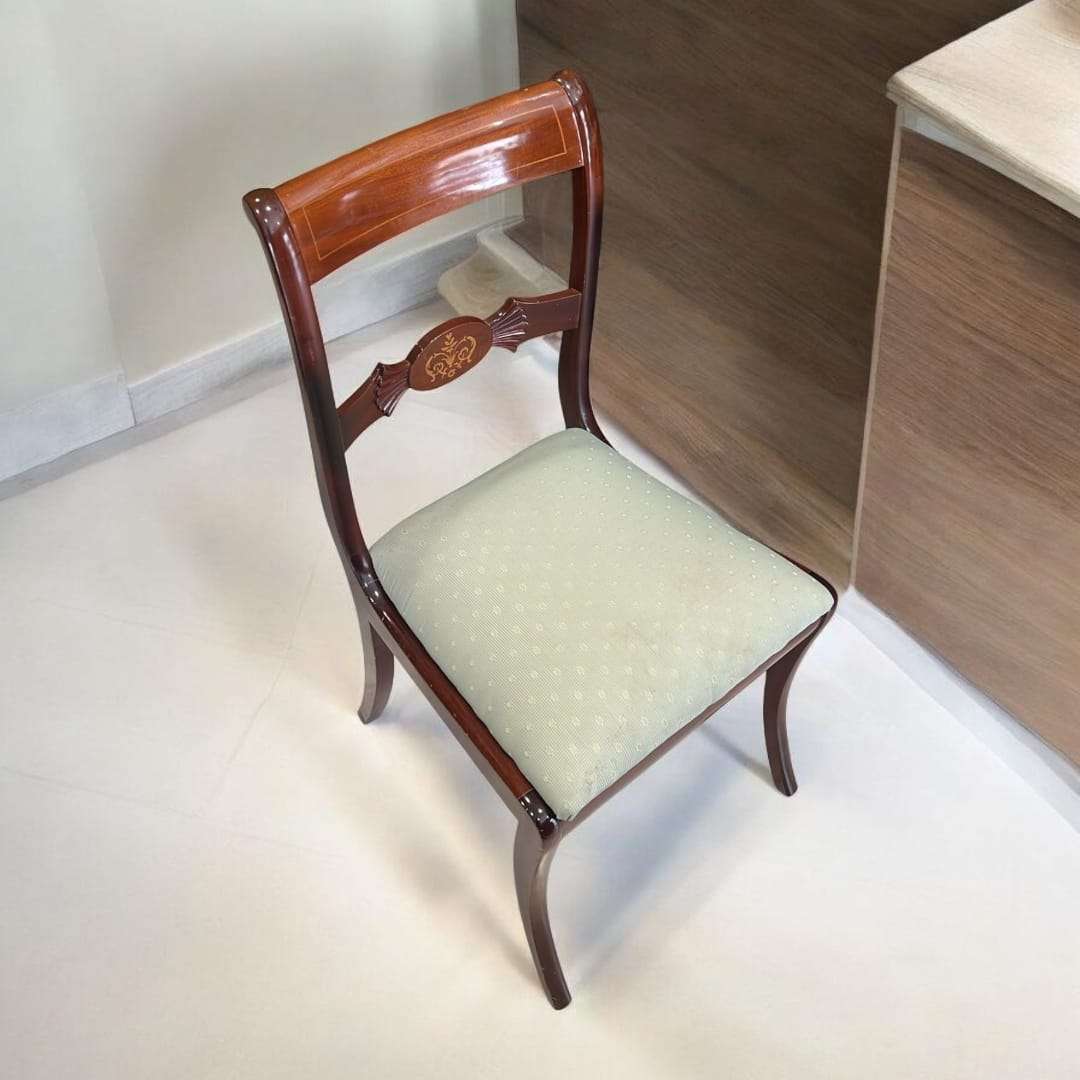 Silla de caoba tapizada con respaldo tallado y asiento acolchado en tela clara. Elegante y cómoda para decoración de interiores clásicos.