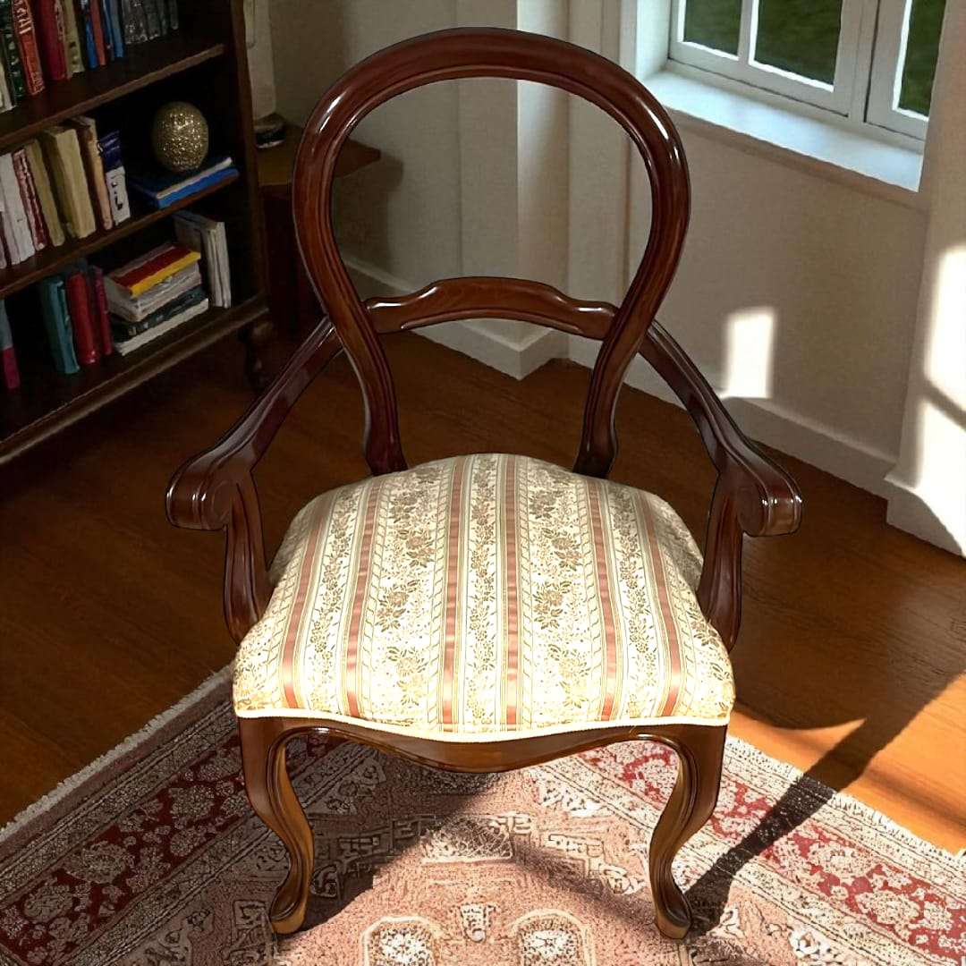 Vista frontal de sillón isabelino de caoba con tapizado floral