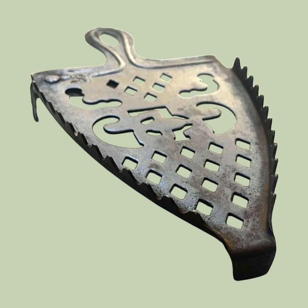 Descansadero de plancha con detalles calados y forma de escudo