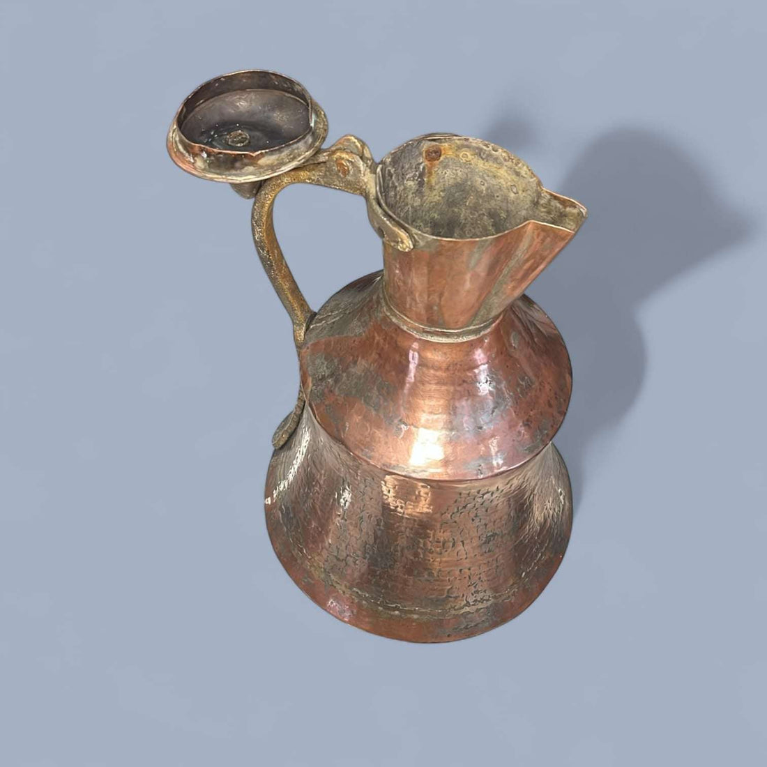 La Jarra de aguamanil antigua de cobre es una pieza tradicional utilizada históricamente para el lavado de manos antes de la instalación de agua corriente en los hogares. 