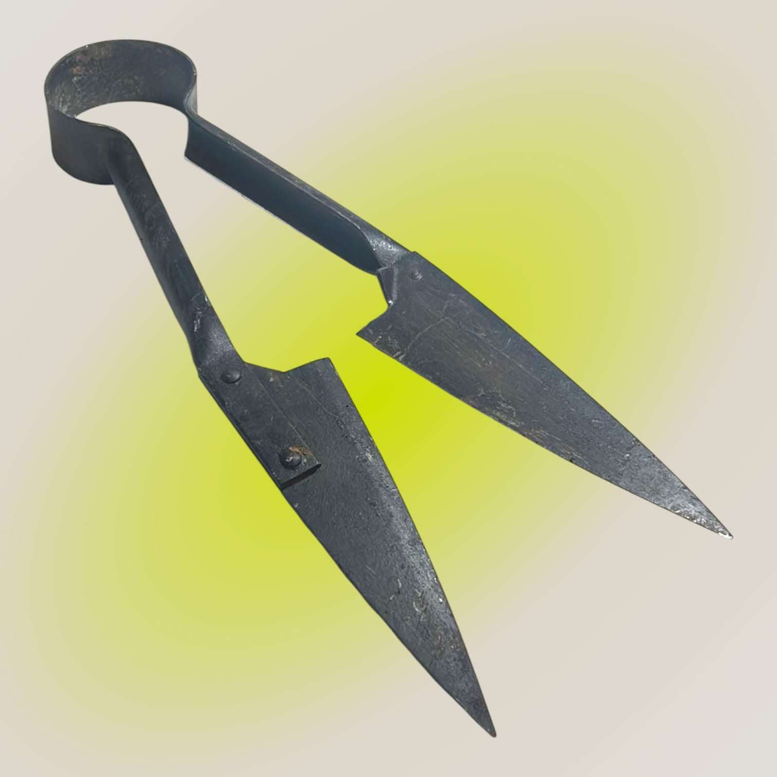 Tijera de esquilar antigua en posición lateral con diseño robusto.