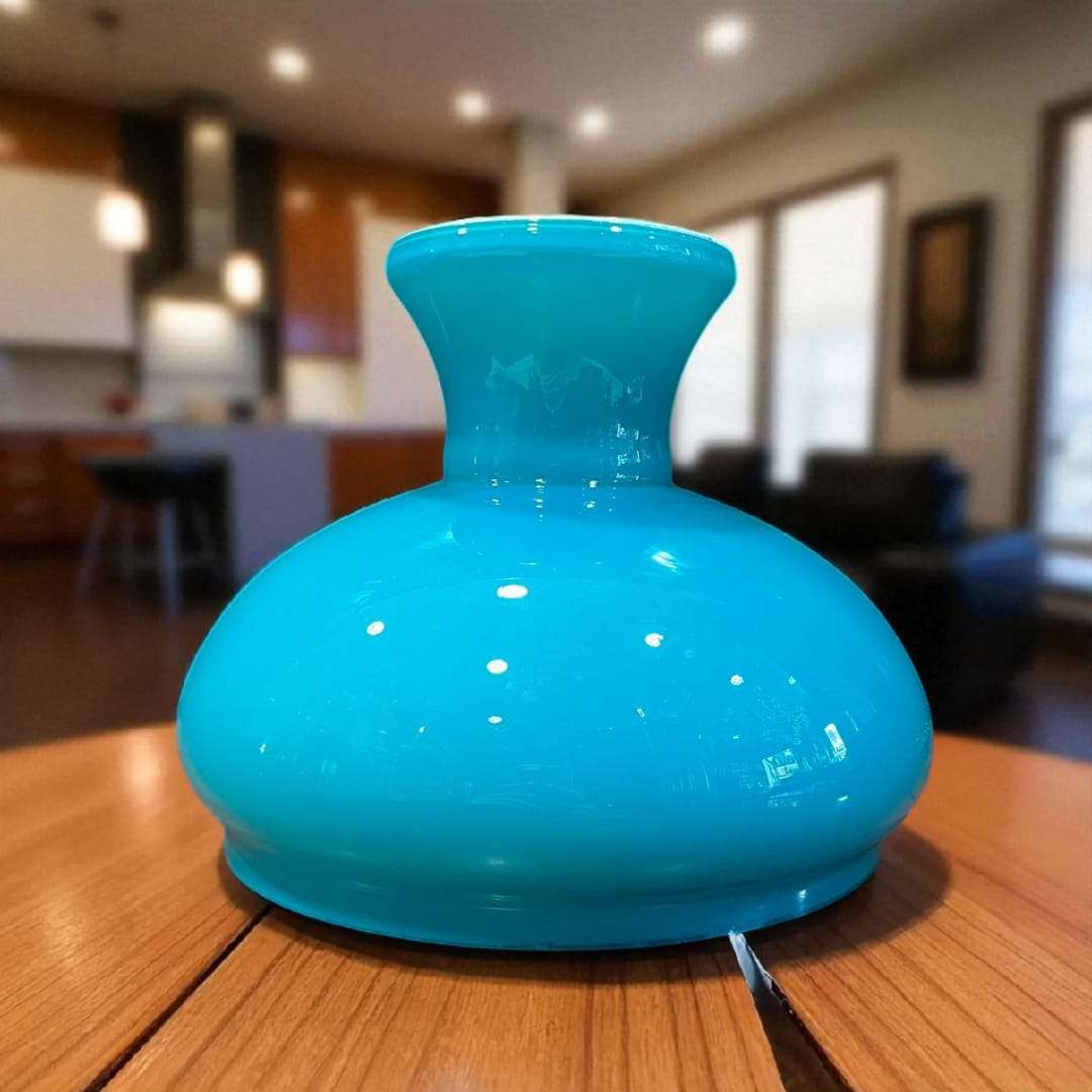 Tulipa de opalina azul celeste sobre mesa de madera.