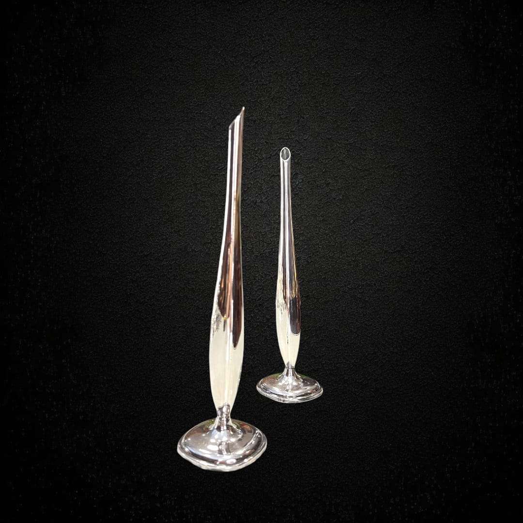 Vista lateral de pareja de violeteros de metal plateado refinados.