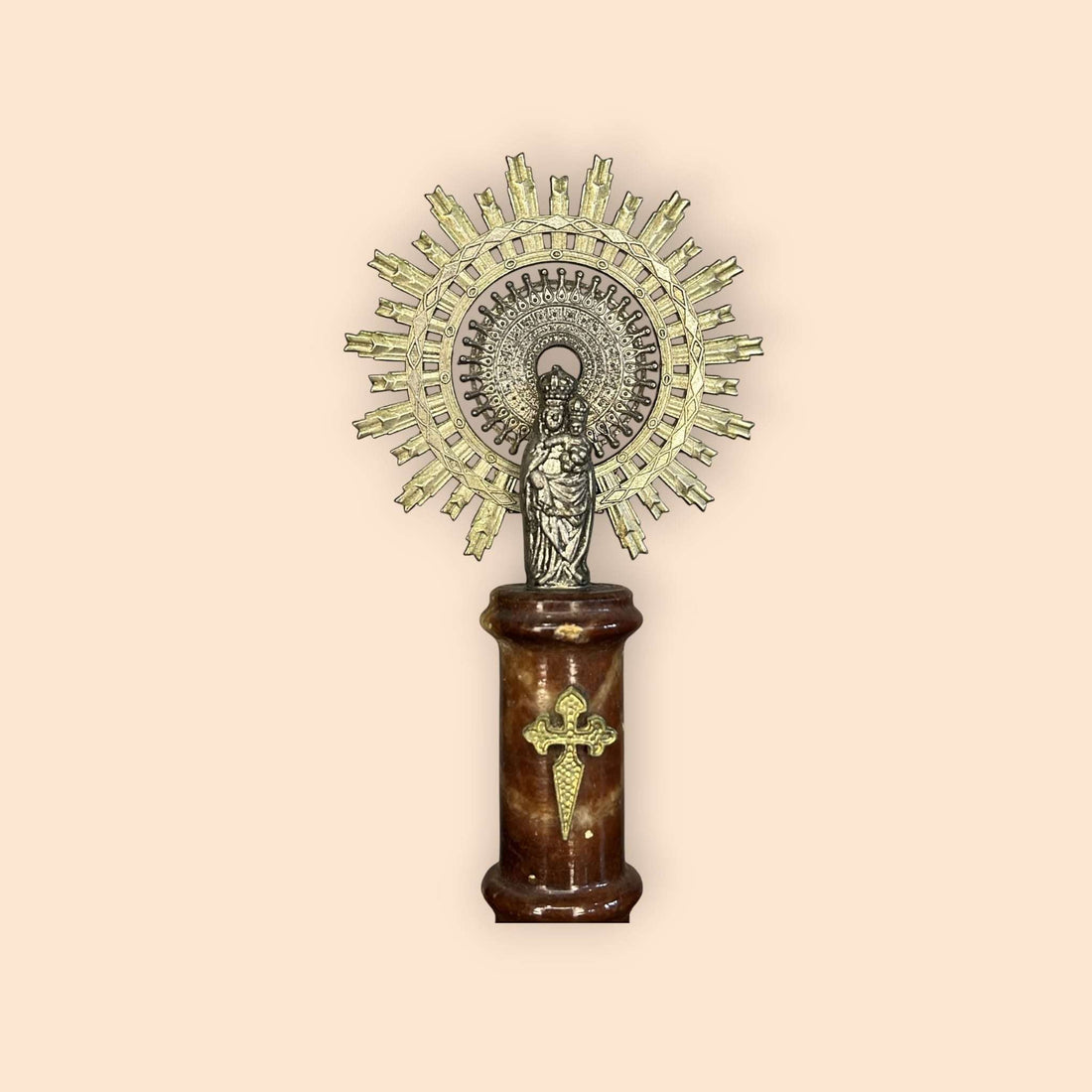 Virgen del Pilar de metal con base y columna de mármol vista frontal.