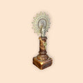 Escultura de la Virgen del Pilar con halo dorado y pedestal rojizo.