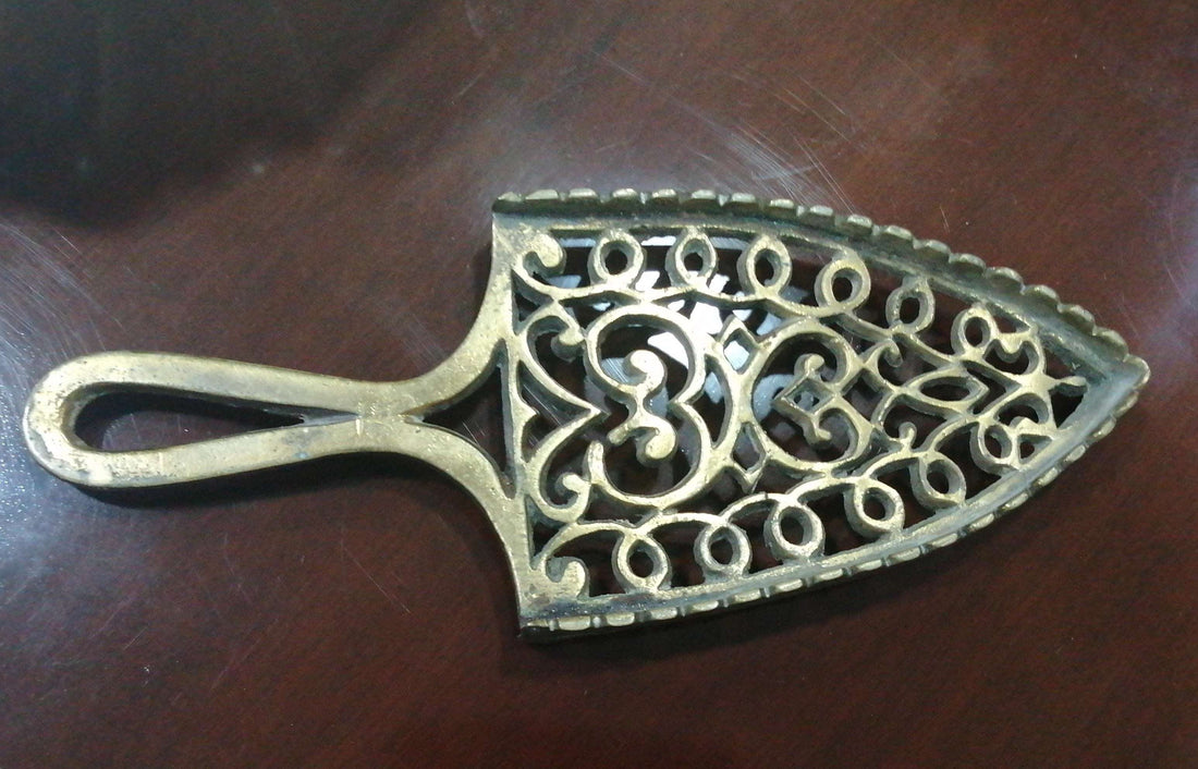 Descansadero Plancha Bronce con diseño calado vintage, ideal para decorar el hogar con estilo clásico. Pieza decorativa de metal en perfecto estado.