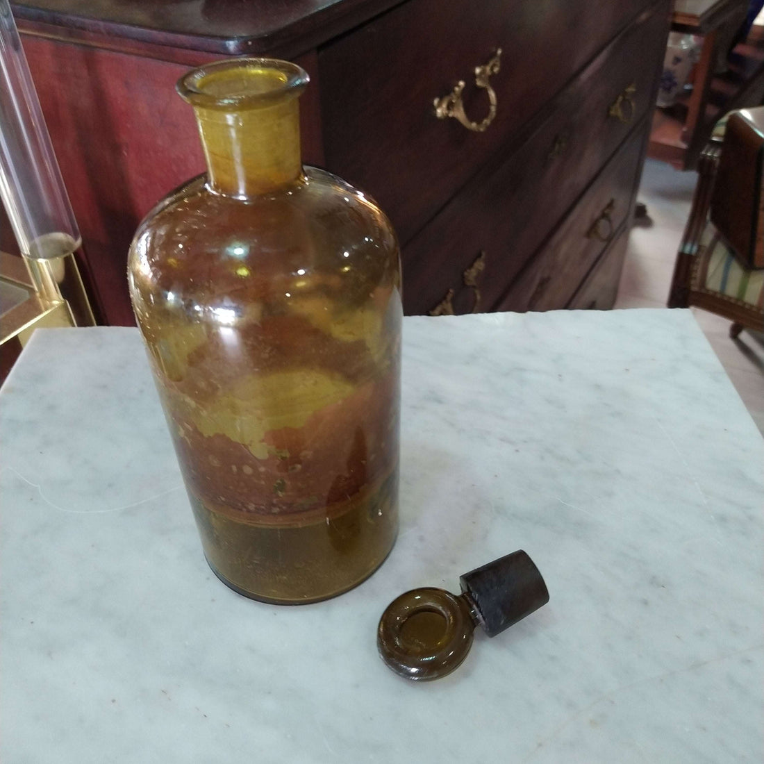 Frasco Farmacia Vintage en vidrio ámbar soplado con tapa original, ideal para decoración retro en hogar o boticas antiguas.