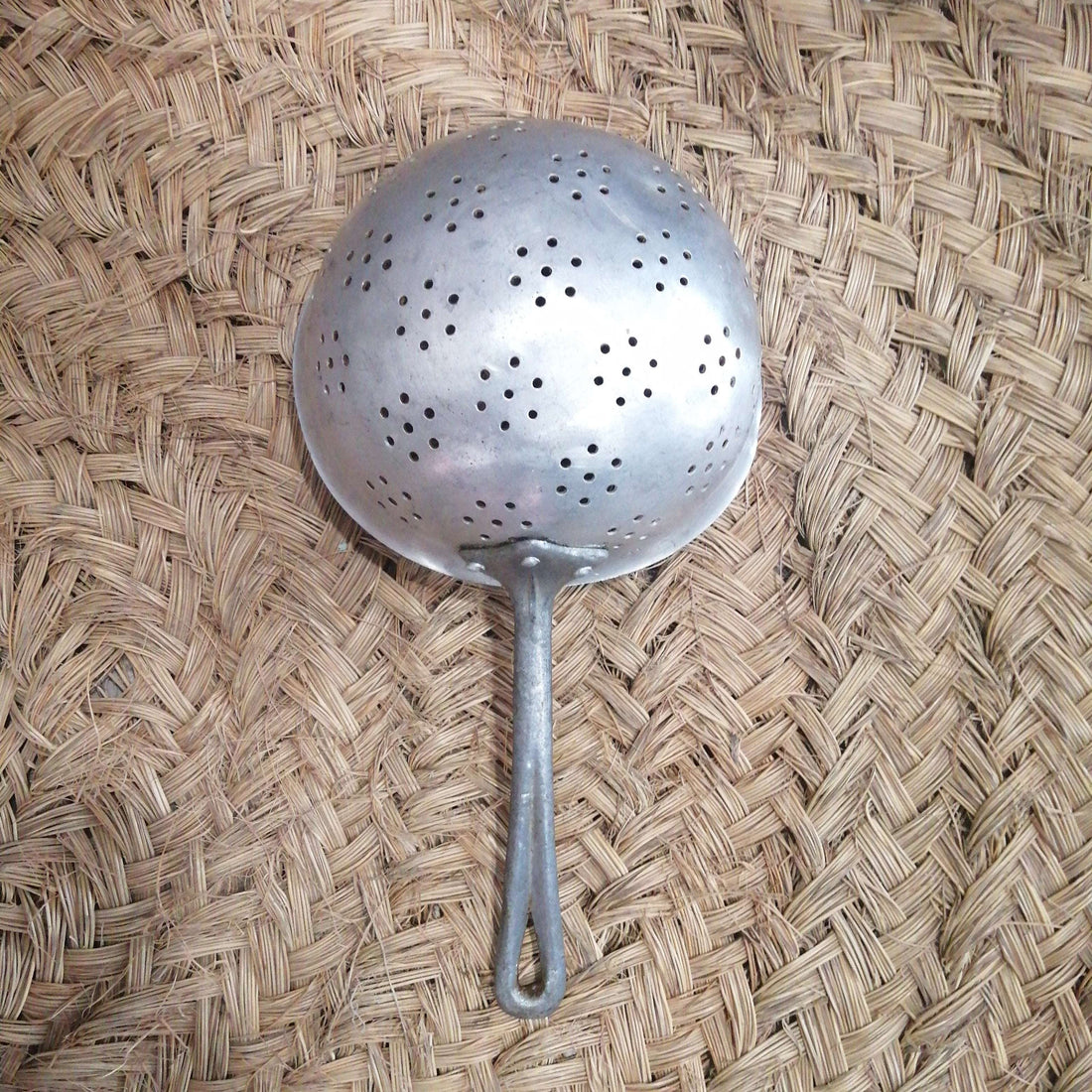 Escurridor de aluminio antiguo en perfecto estado con mango largo, ideal para decoración vintage en cocina rústica o uso funcional.