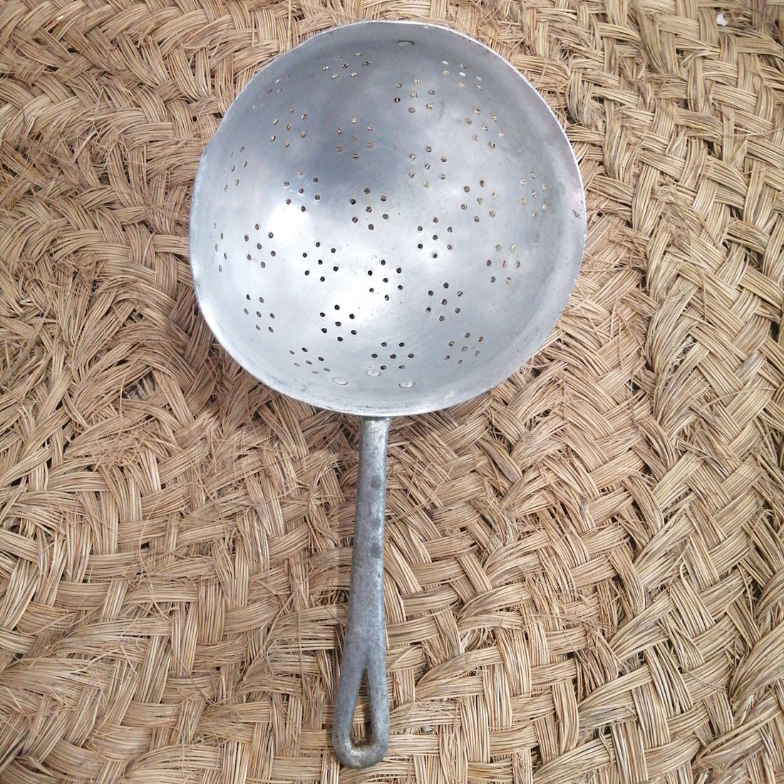 Escurridor de aluminio antiguo en perfecto estado con mango largo, ideal para decoración vintage en cocina rústica o uso funcional.