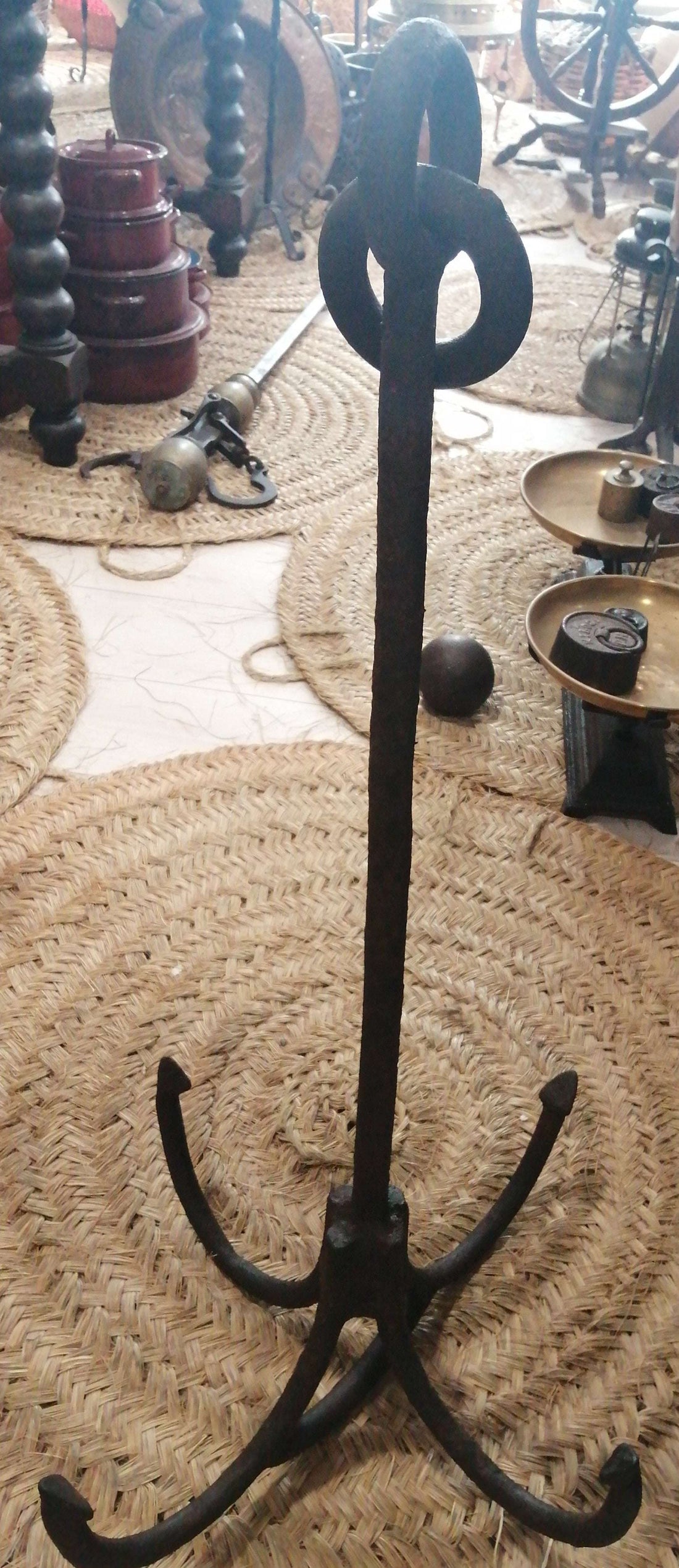 Ancla de hierro antigua con cuatro ganchos curvos, ideal como pieza decorativa náutica de excelente calidad para el hogar o jardín.