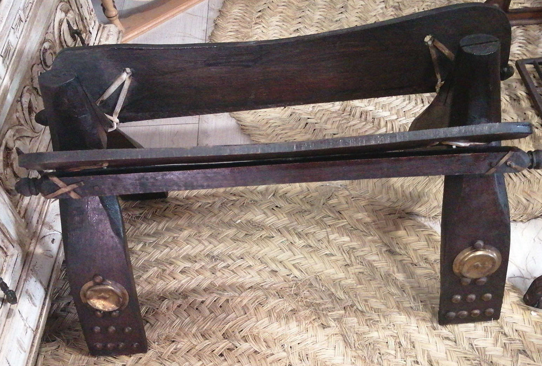 Montura de camello de madera antigua con detalles en bronce, ideal para decoración rústica o coleccionismo étnico en el hogar.