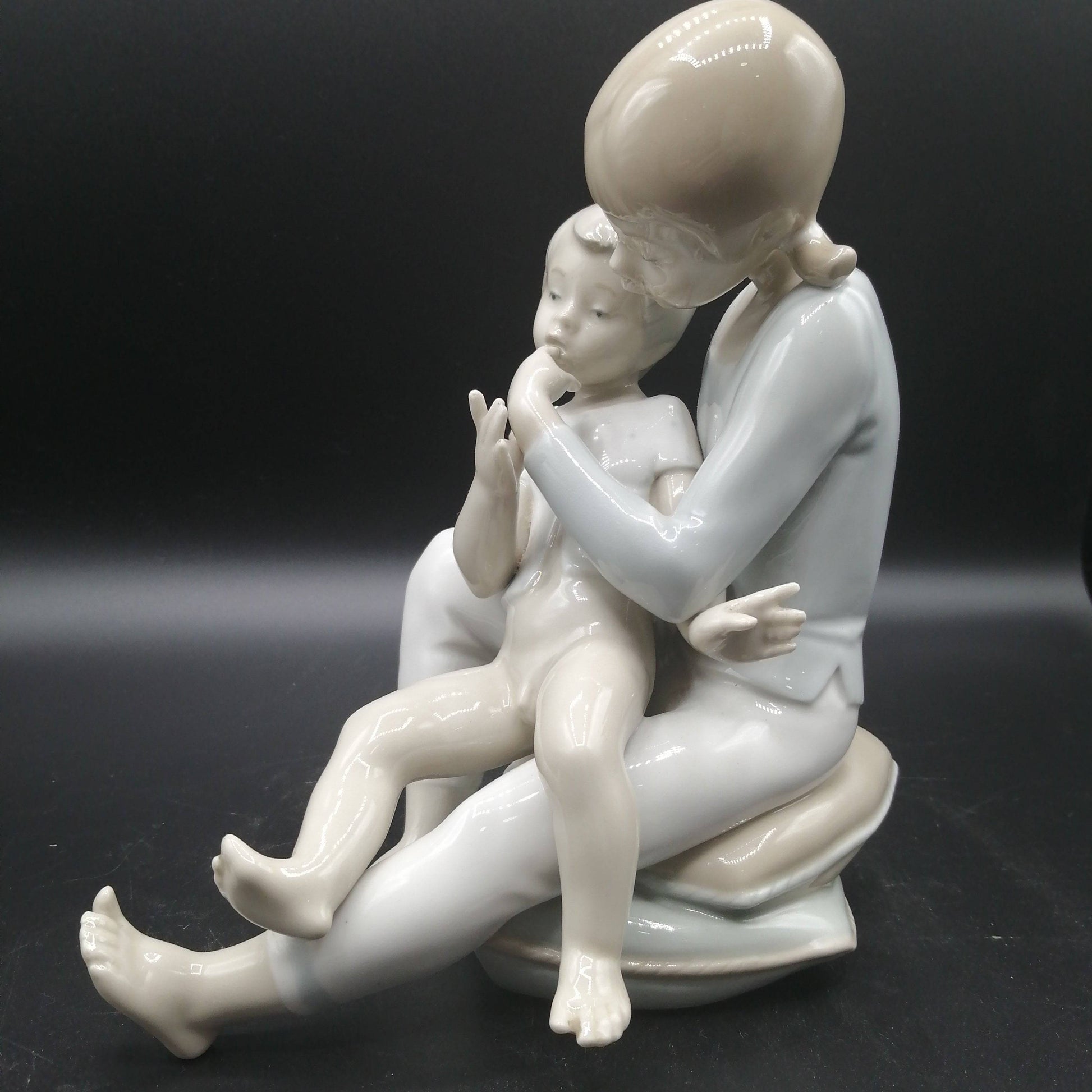 Vista lateral de figura de porcelana niño y niña sentada | Elegancia y calidad, perfecta para decoración clásica y coleccionistas.