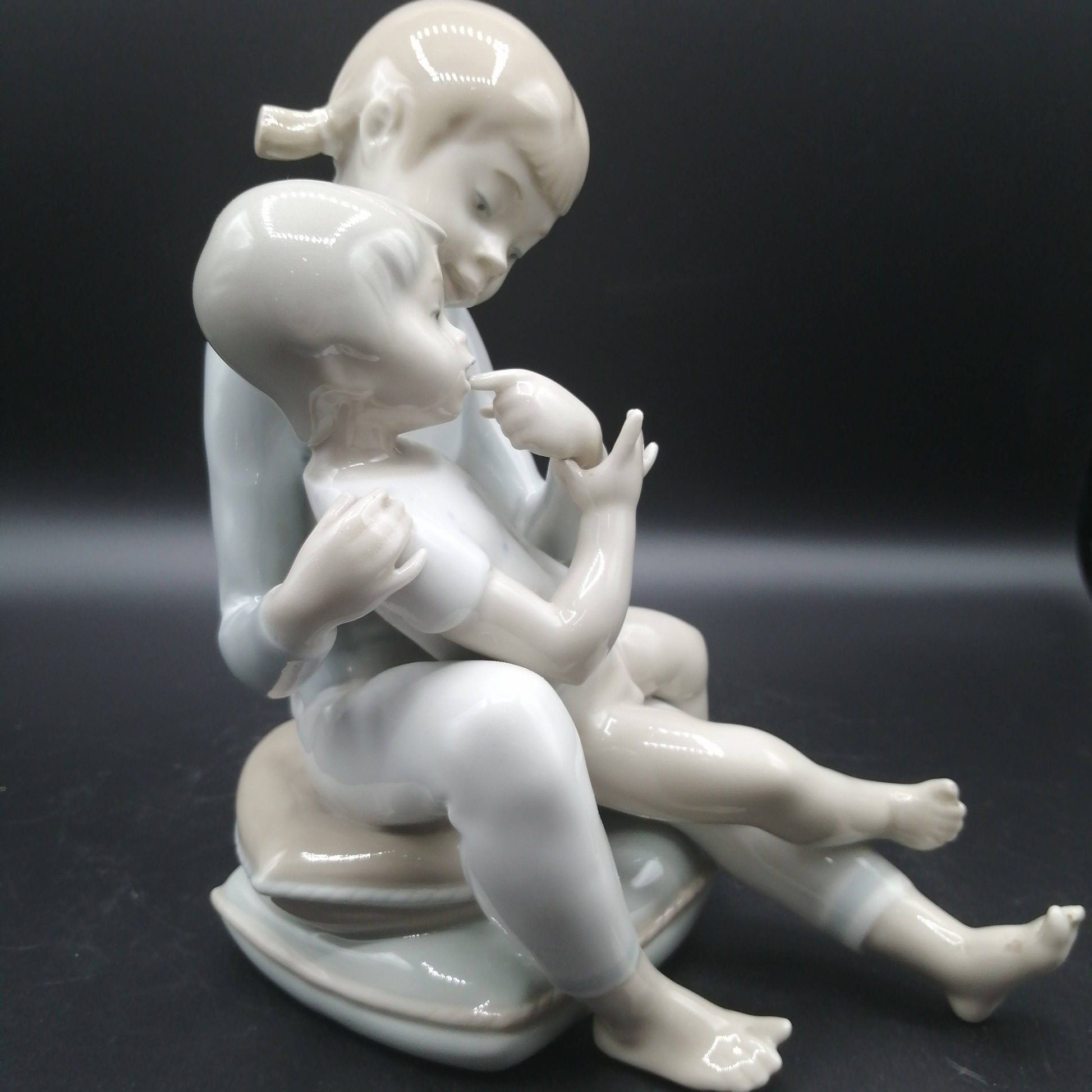 Figura de porcelana niño y niña sentada | Elegancia y calidad con diseño armonioso y estilo vintage para decoración de interiores.