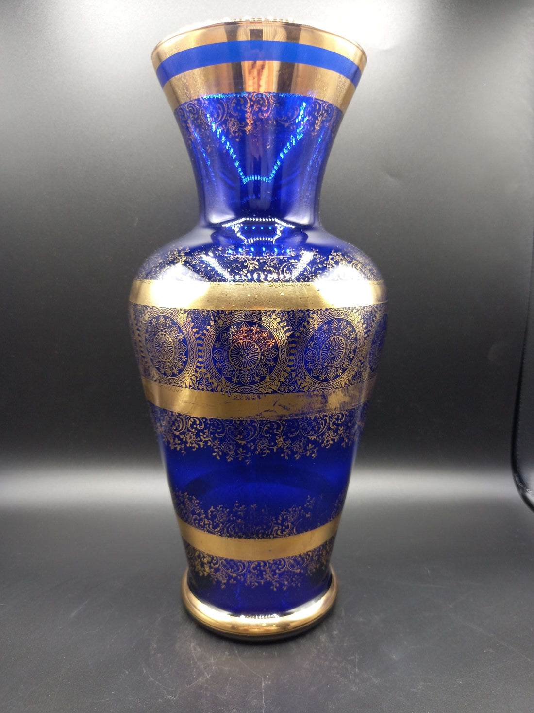 Jarrón de cristal azul cobalto y oro de lujo con detalles ornamentales dorados, ideal para decoración elegante en el hogar. Excelente calidad artesanal.