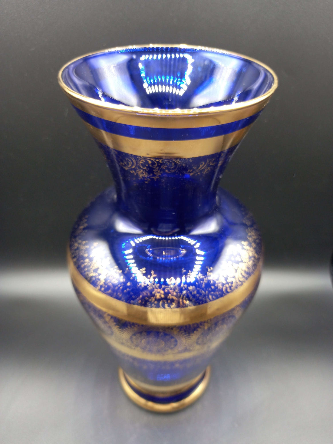 Jarrón de cristal azul cobalto y oro de lujo con detalles ornamentales dorados, ideal para decoración elegante en el hogar. Excelente calidad artesanal.