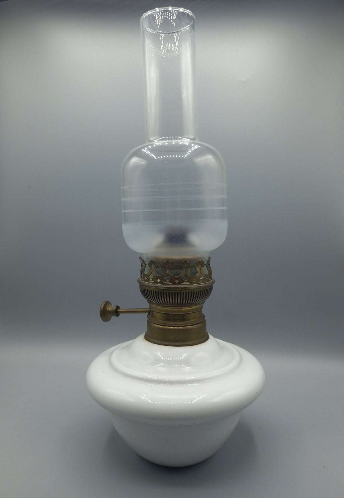 Quinque de opalina blanca para mesa con base redonda y detalles en latón. Decoración vintage ideal para hogar elegante y clásico.