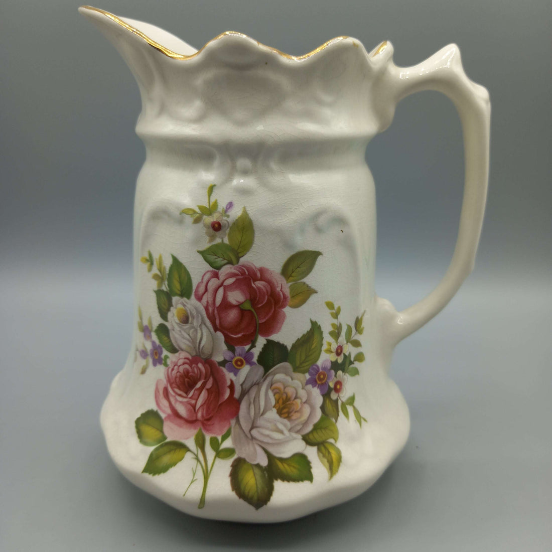 Jarra de porcelana inglesa con diseño floral vintage, ideal para decoración de interiores en estilo clásico. Antigüedad y calidad destacada.