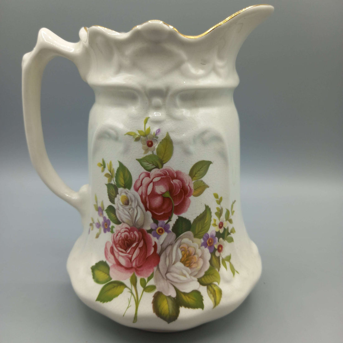 Jarra de porcelana inglesa con diseño floral vintage, ideal para decoración de interiores en estilo clásico. Antigüedad y calidad destacada.