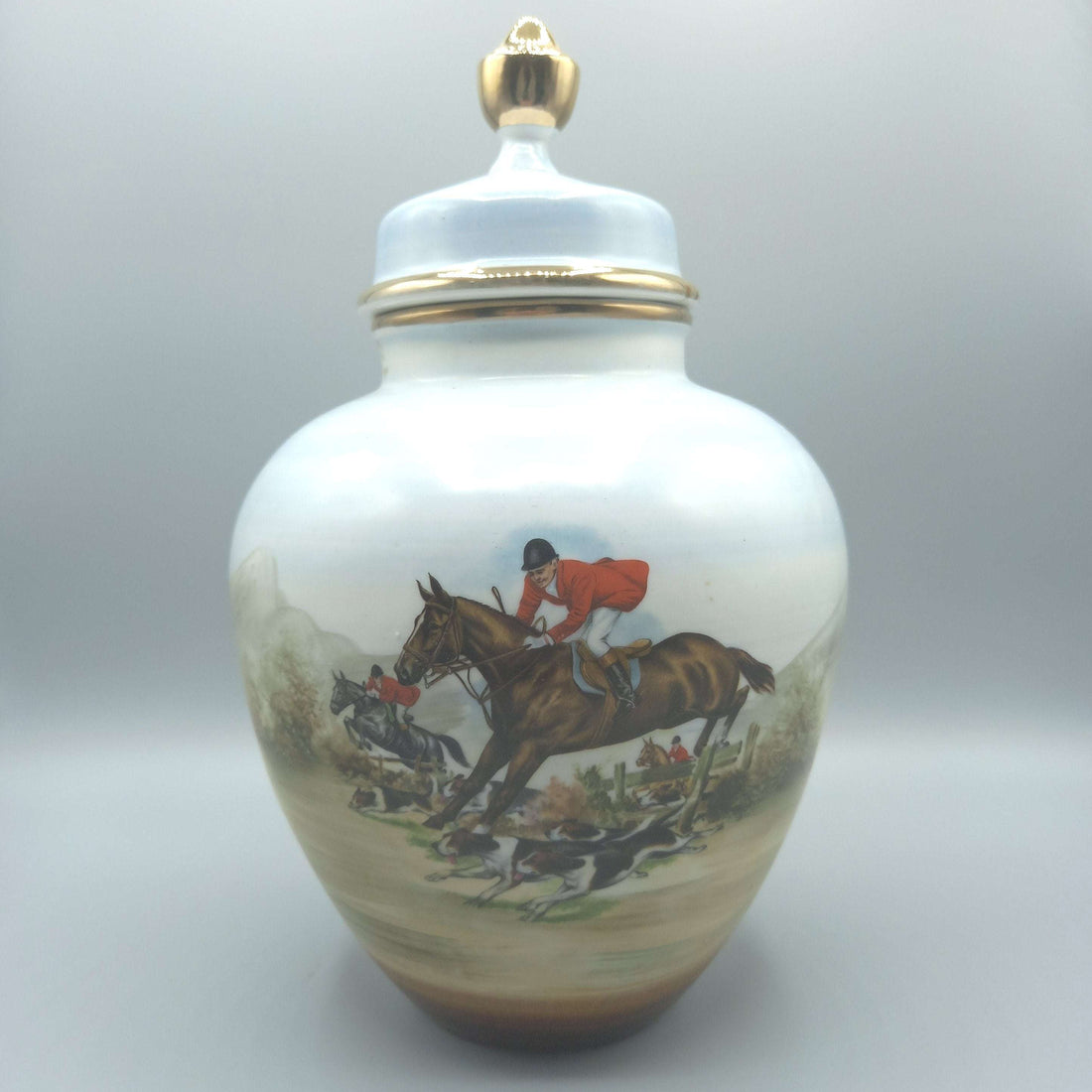 Tibor de porcelana pintado a mano con cacería inglesa, exclusivo, decorado con escena ecuestre y detalles dorados. Ideal para decoración clásica.