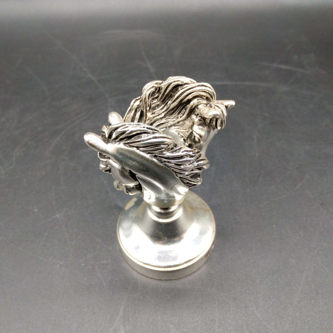 Sello de lacre caballos en metal plateado de 7cm con diseño detallado de dos cabezas de caballo entrelazadas. Ideal para decoración vintage o coleccionismo.