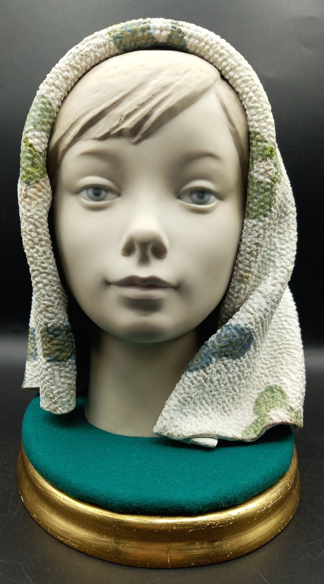 Figura Lladró de chica con manta en porcelana de excelente calidad, sobre base verde y dorada, ideal para decoración de interiores.