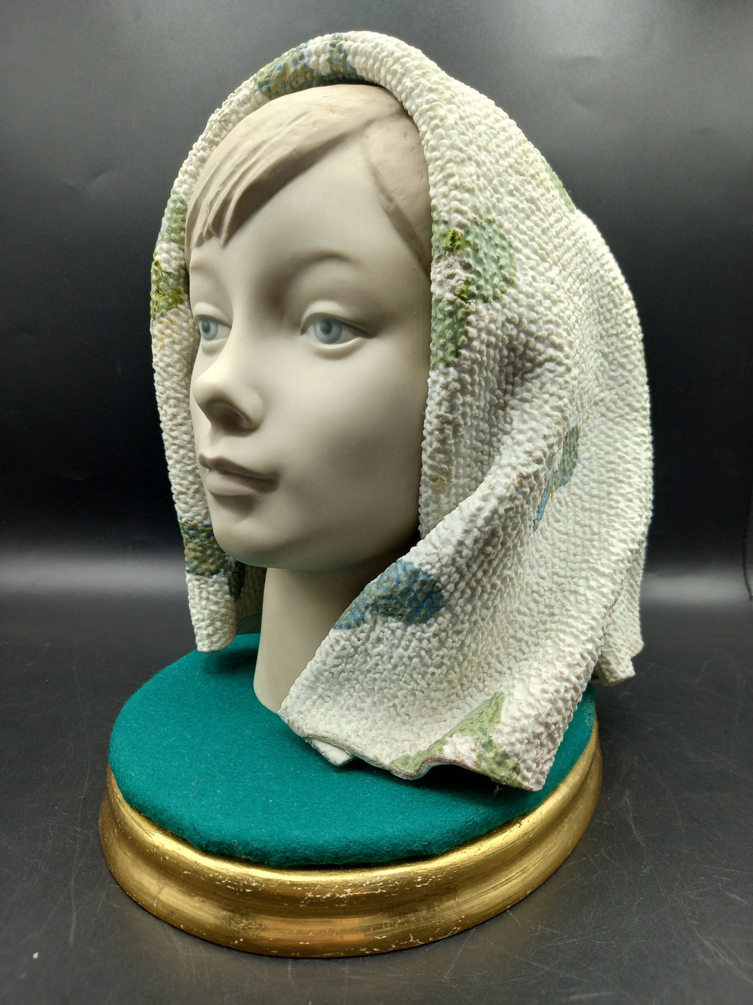 Figura Lladró de chica con manta en porcelana de excelente calidad, sobre base verde y dorada, ideal para decoración de interiores.