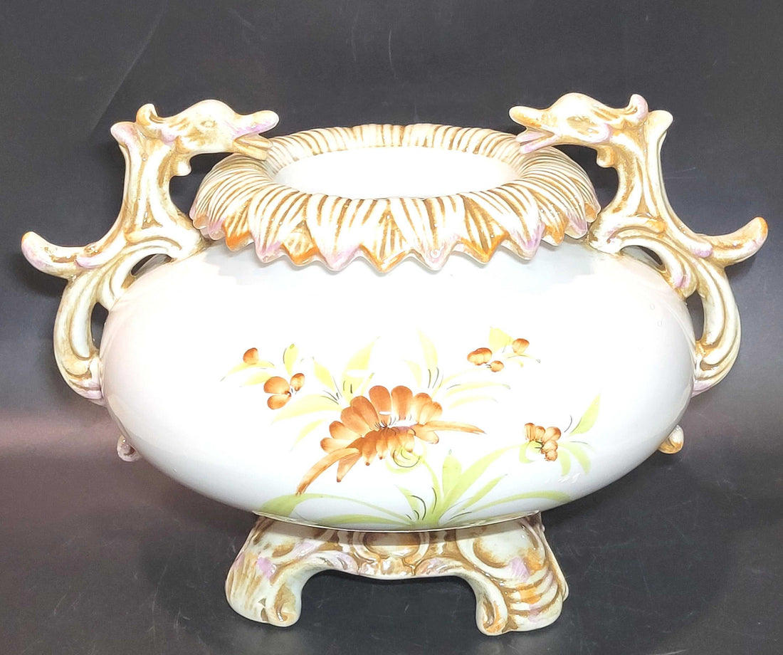 Centro de mesa elegante y antiguo de porcelana pintado a mano con asas ornamentales y flores coloridas. Ideal para decoración de interiores clásicos.