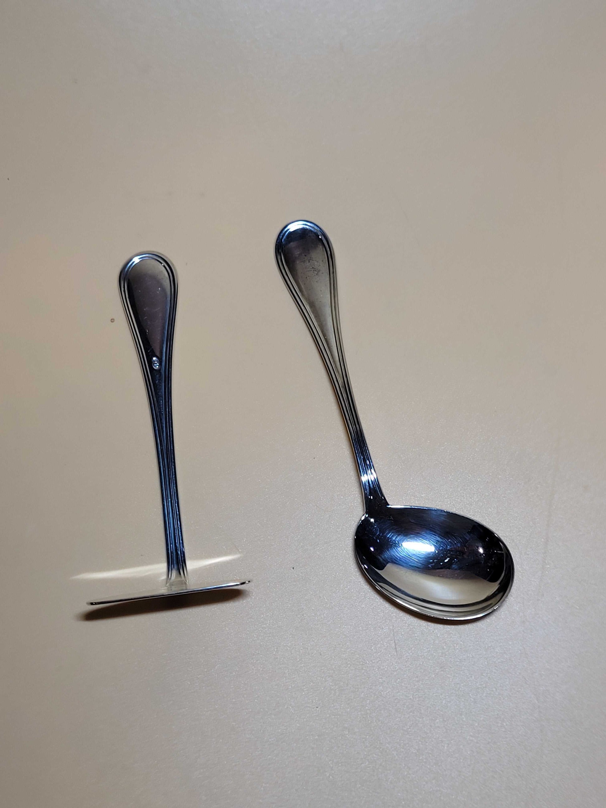 Cucharas para niños en metal plateado decoradas con diseño clásico y elegante, ideales para decoración en hogar y jardín.