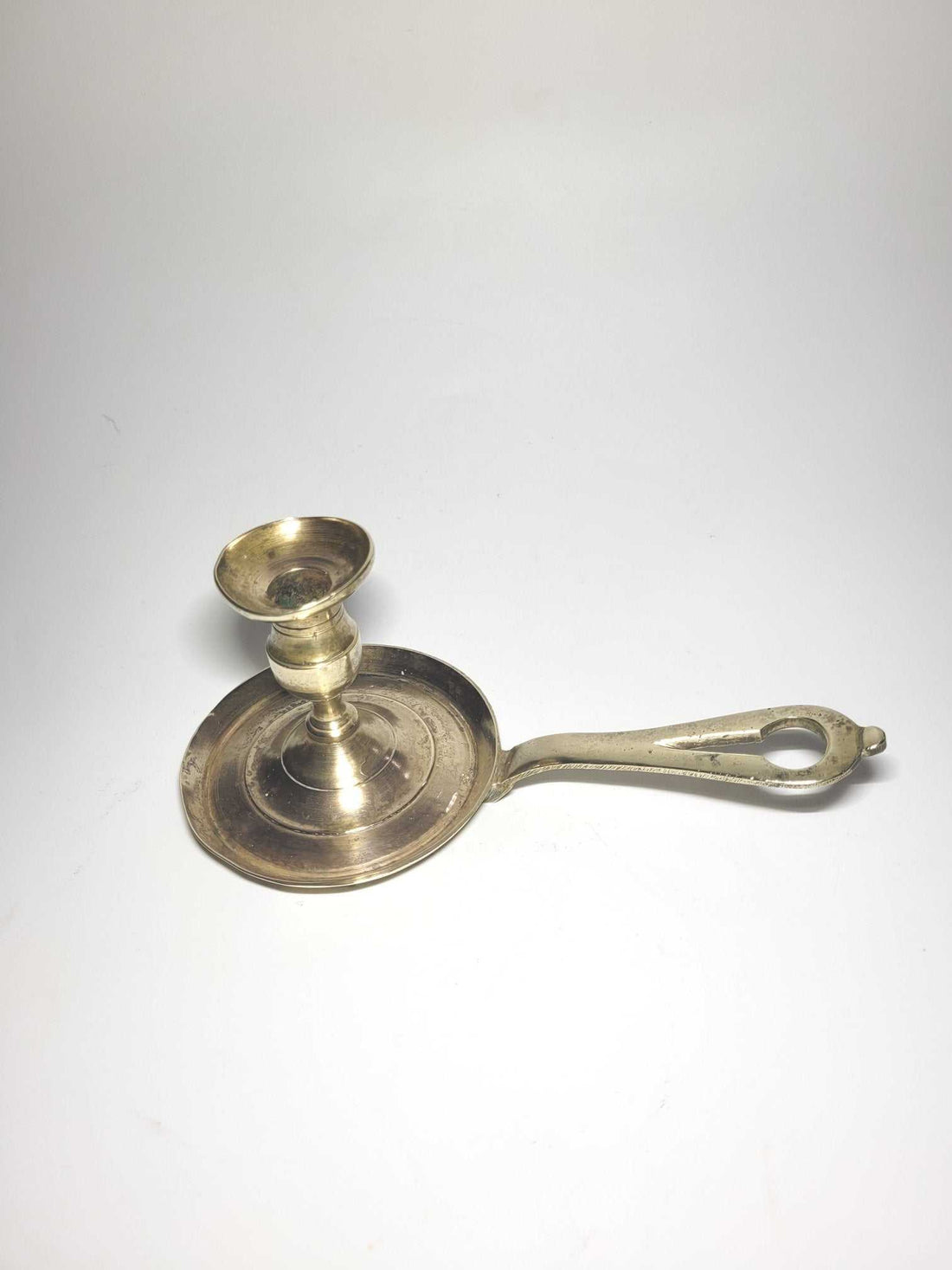 Palmatoria antigua con mango de metal, diseño vintage ideal para decoración elegante en el hogar. Perfecta para ambientes cálidos y clásicos.