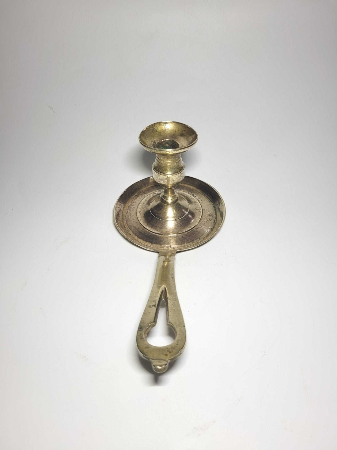 Palmatoria antigua con mango de metal, diseño vintage ideal para decoración elegante en el hogar. Perfecta para ambientes cálidos y clásicos.