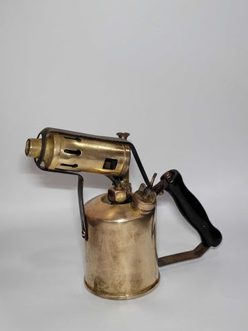 Lámparilla de fontanero antigua de colección en latón con mango negro, estilo vintage ideal para decoración rústica o industrial.