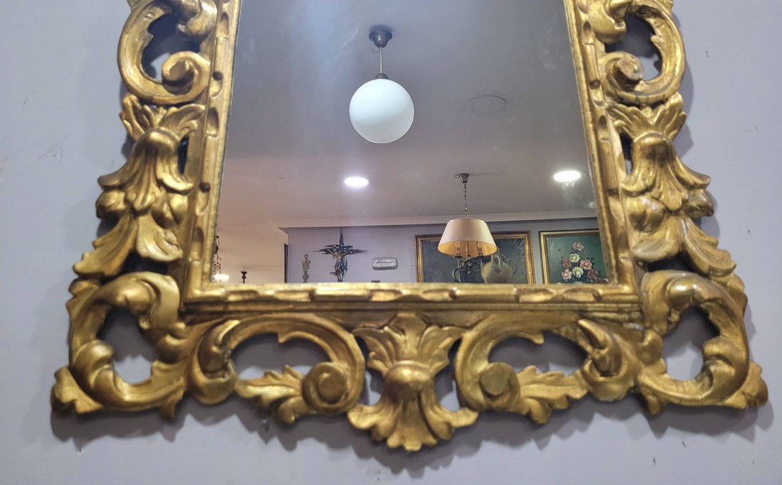 Espejo Isabelino Dorado con penacho tallado del siglo XIX, marco ornamentado en madera dorada ideal para decoración histórica de interiores.