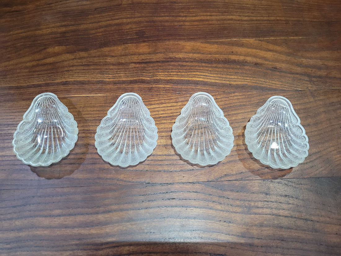Conjunto de conchas bautismales de cristal antiguas de alta calidad sobre mesa de madera, ideales para decoración de ceremonias religiosas.