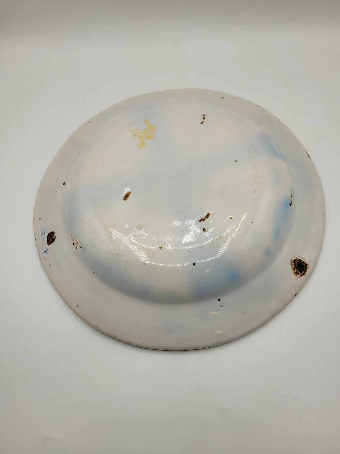 Plato antiguo decorado con flor central y guirnalda azul