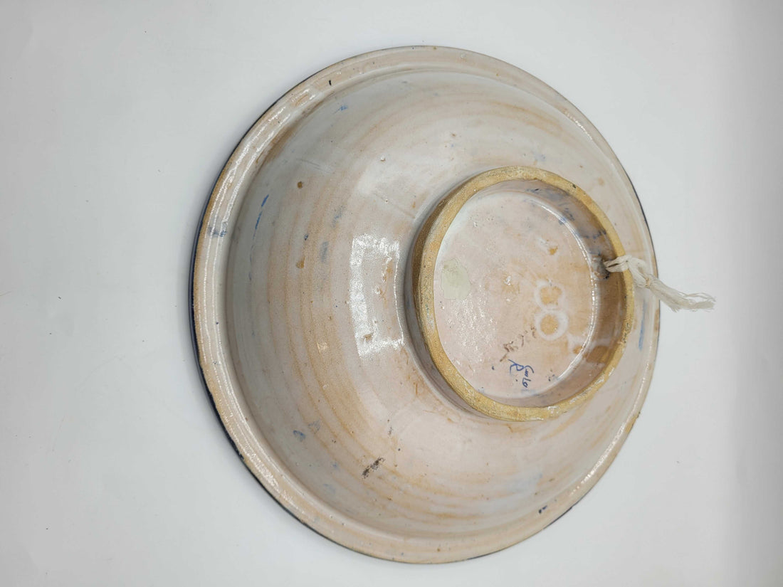 Plato árabe antiguo de cerámica con decoración simétrica pintada a mano.