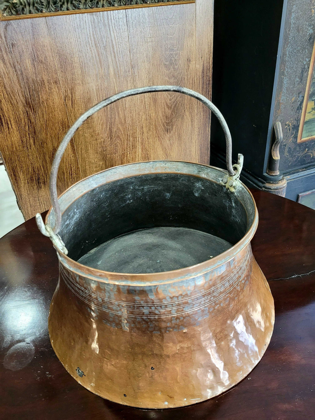 Caldero de cobre antiguo de cuerpo redondeado con asa lateral robusta y pátina natural.

