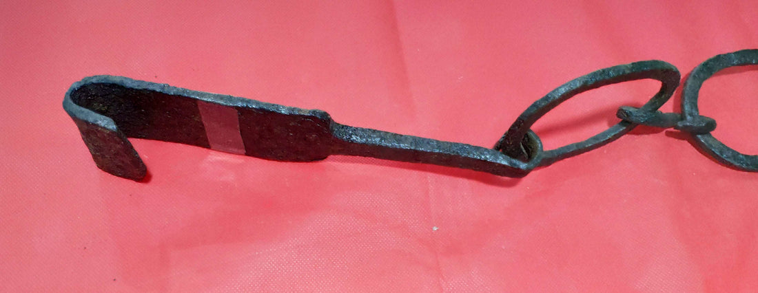 Cadena en la chimenea para colgar calderos de hierro forjado, estilo antiguo, sobre fondo rojo. Ideal para decoración rústica o vintage.