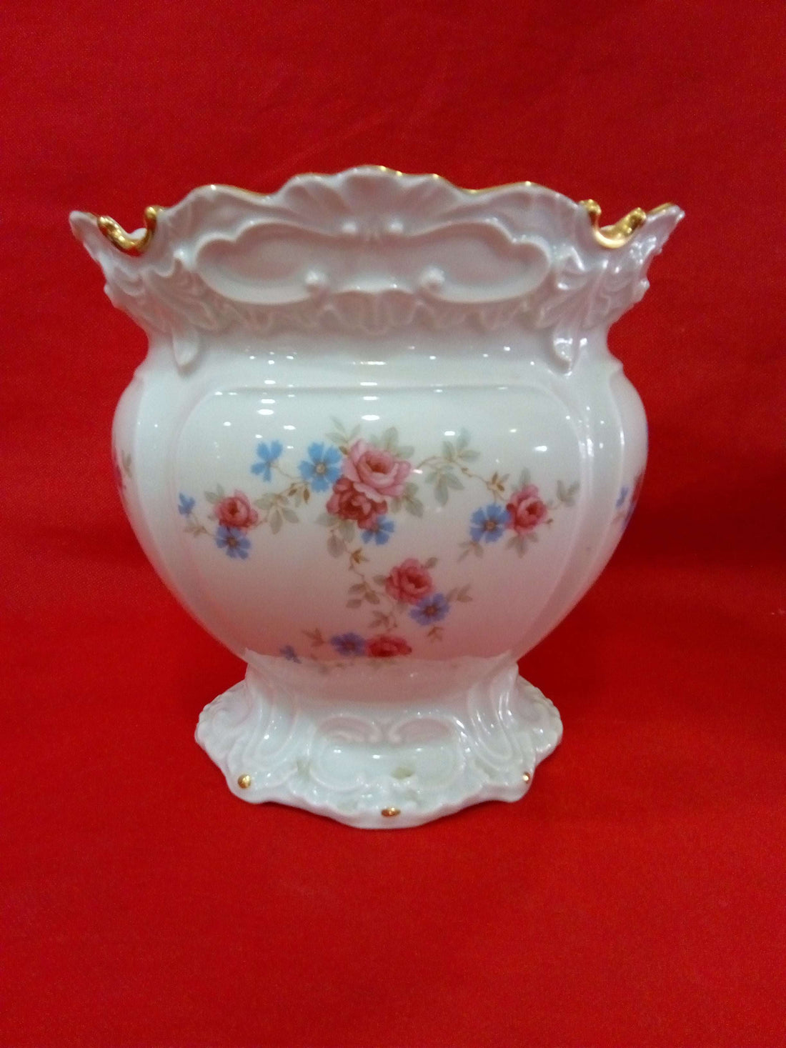 Macetero de porcelana de alta calidad con diseño floral en tonos pastel y bordes dorados, ideal para decoración elegante en el hogar.